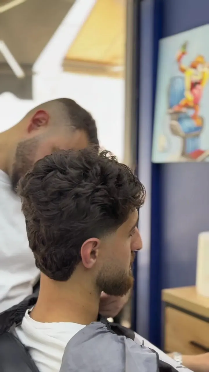 A client's curly hair being shaped at Eri's Barbershop